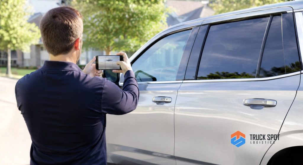 TSL How to Ship a Car You Bought Online (5) Using a smartphone to document the exterior condition of a vehicle before loading it onto a transport truck.