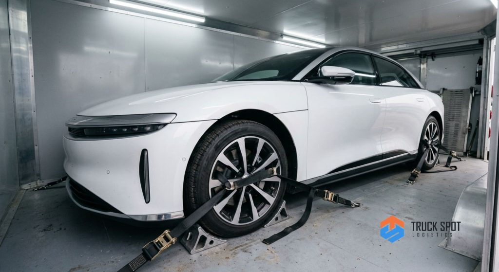 TSL How to Ship a Car to Another State 2026 Moving Guide (2) Premium American electric sedan protected inside an enclosed auto transport trailer for maximum security.